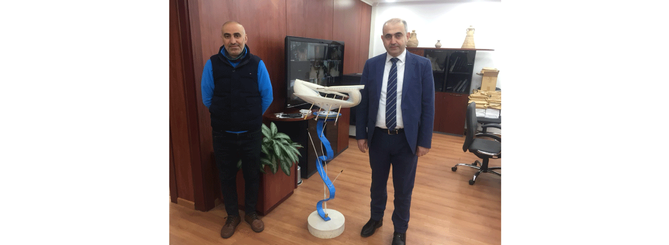 President Bassam Badran receives a sculpture from Dr. Ali Harkous